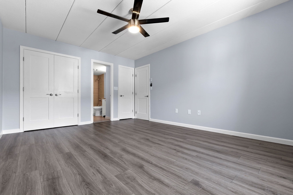 133 Franklin Street, Unit 503 Stoneham, MA 02180 - Photo 11 of 23 an empty room with wooden floor and windows