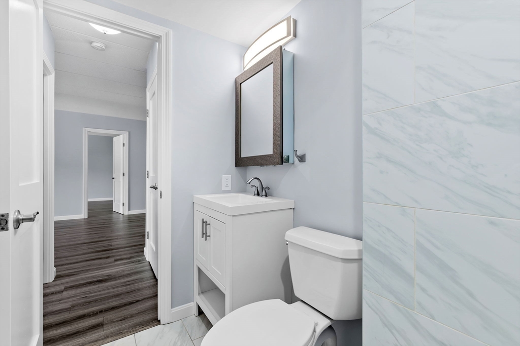 133 Franklin Street, Unit 503 Stoneham, MA 02180 - Photo 16 of 23 a bathroom with a toilet sink and mirror