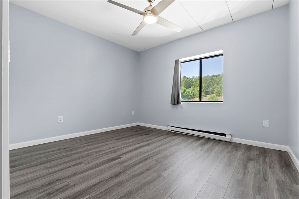 133 Franklin Street, Unit 503 Stoneham, MA 02180 - Photo 18 of 23 an empty room with wooden floor and windows