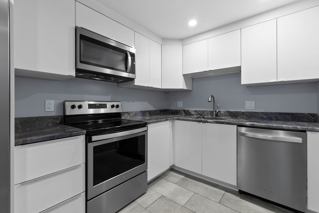 133 Franklin Street, Unit 503 Stoneham, MA 02180 - Photo 3 of 23 a kitchen with stainless steel appliances granite countertop grey cabinets a stove a sink and dishwasher
