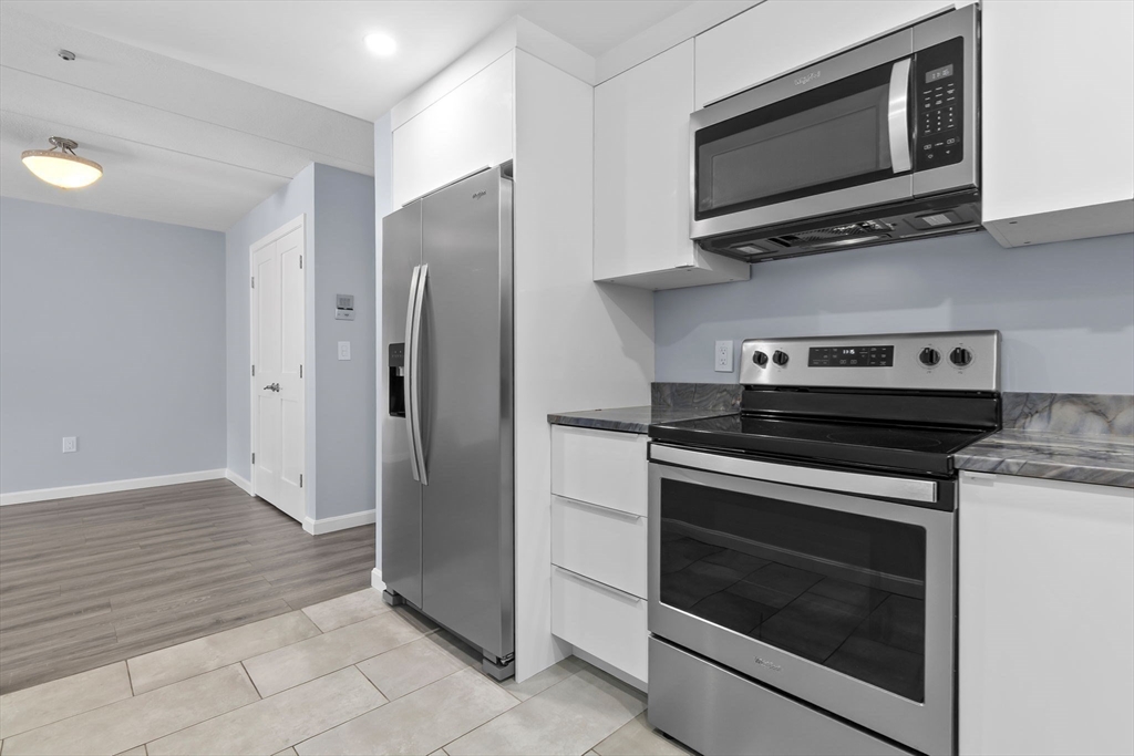 133 Franklin Street, Unit 503 Stoneham, MA 02180 - Photo 4 of 23 a kitchen with cabinets and stainless steel appliances
