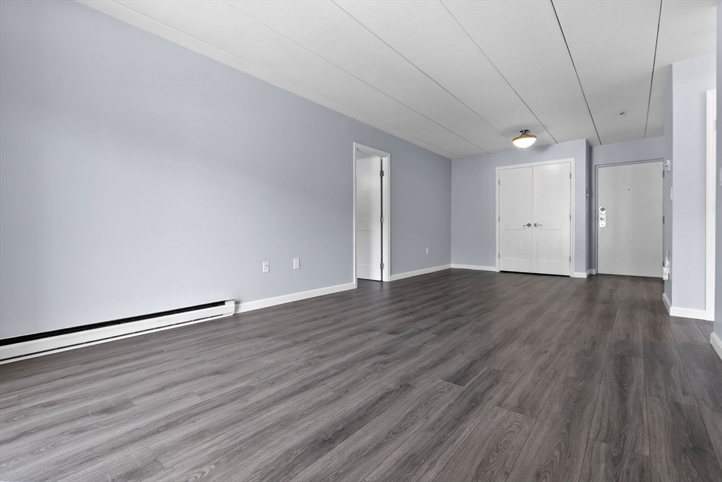 133 Franklin Street, Unit 503 Stoneham, MA 02180 - Photo 7 of 23 a view of an empty room with wooden floor