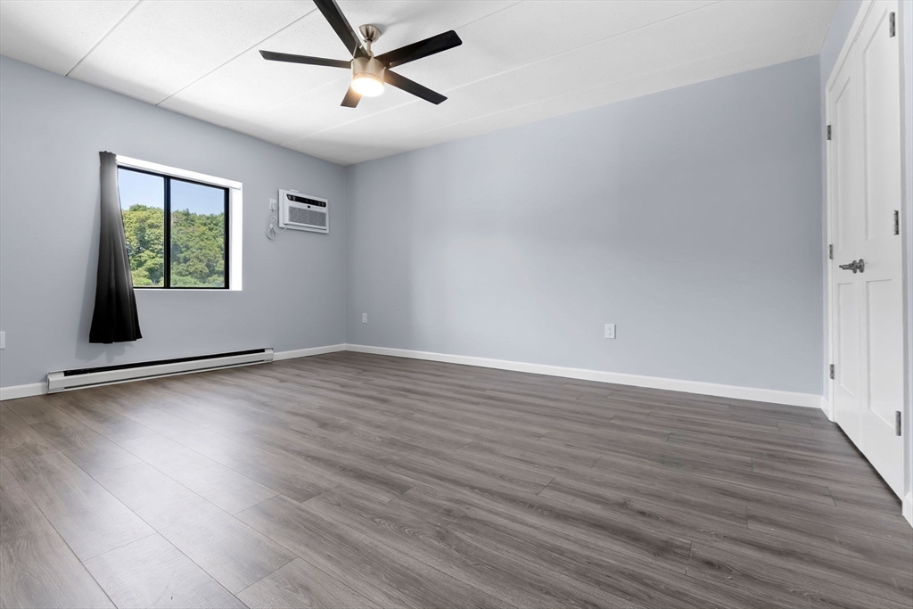 133 Franklin Street, Unit 503 Stoneham, MA 02180 - Photo 10 of 23 a view of empty room with wooden floor and fan