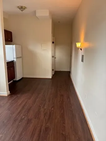 an empty room with wooden floor and a fireplace