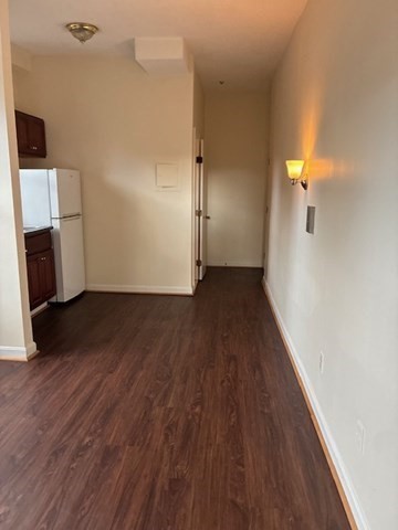 59 South Huntington Avenue, Unit 8 Boston, MA 02130 - Photo 2 of 5 an empty room with wooden floor and a fireplace