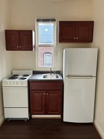 a kitchen with a refrigerator sink and cabinets