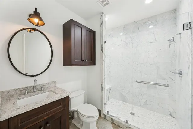 a bathroom with a granite countertop sink toilet and shower