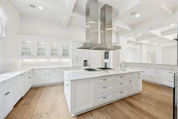 a large kitchen with a lot of counter space and wooden floor
