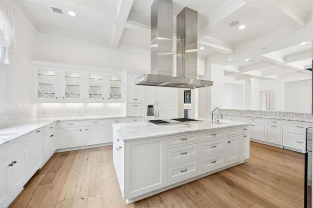 a large kitchen with a lot of counter space and wooden floor