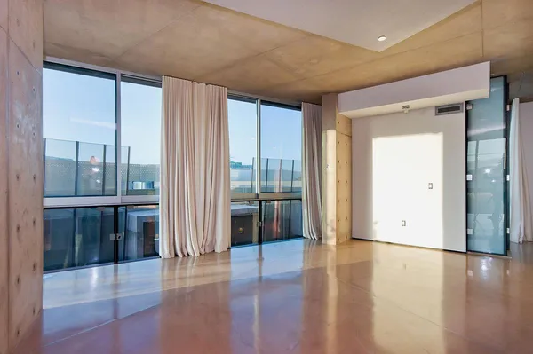 a view of a hallway with wooden floor and cabinet