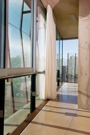 a bedroom with a bed and large windows