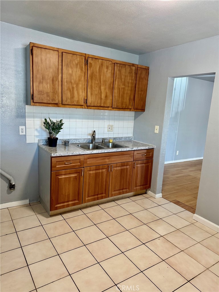 12931 Fourth Street Chino, CA 91710 - Photo 8 of 34 a kitchen with a sink a stove cabinets and utility room
