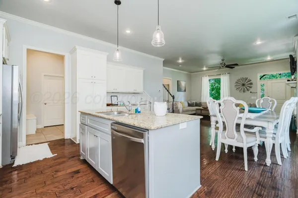 a kitchen with a dining table chairs and white cabinets