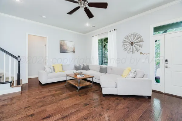 a living room with furniture and a wooden floor