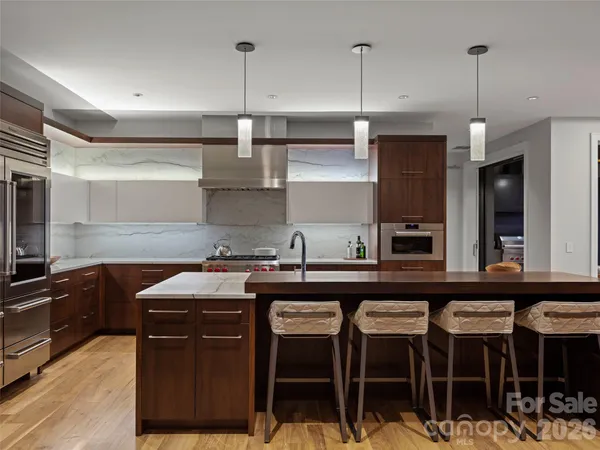 a kitchen with granite countertop a sink a counter space appliances and cabinets