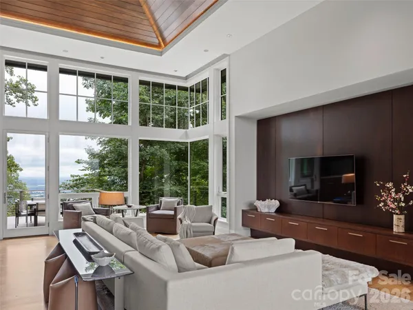 a living room with furniture a large window and a flat screen tv