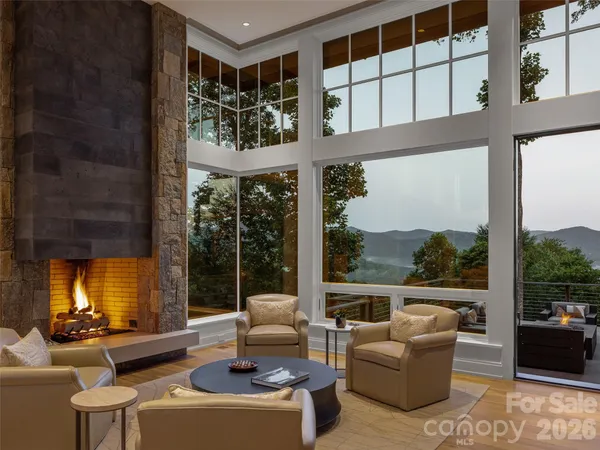 a living room with fireplace furniture and a large window