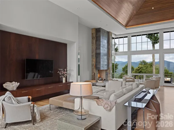 a living room with furniture a flat screen tv and a large window