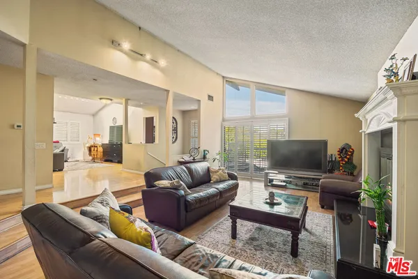 a living room with furniture a flat screen tv and a large window