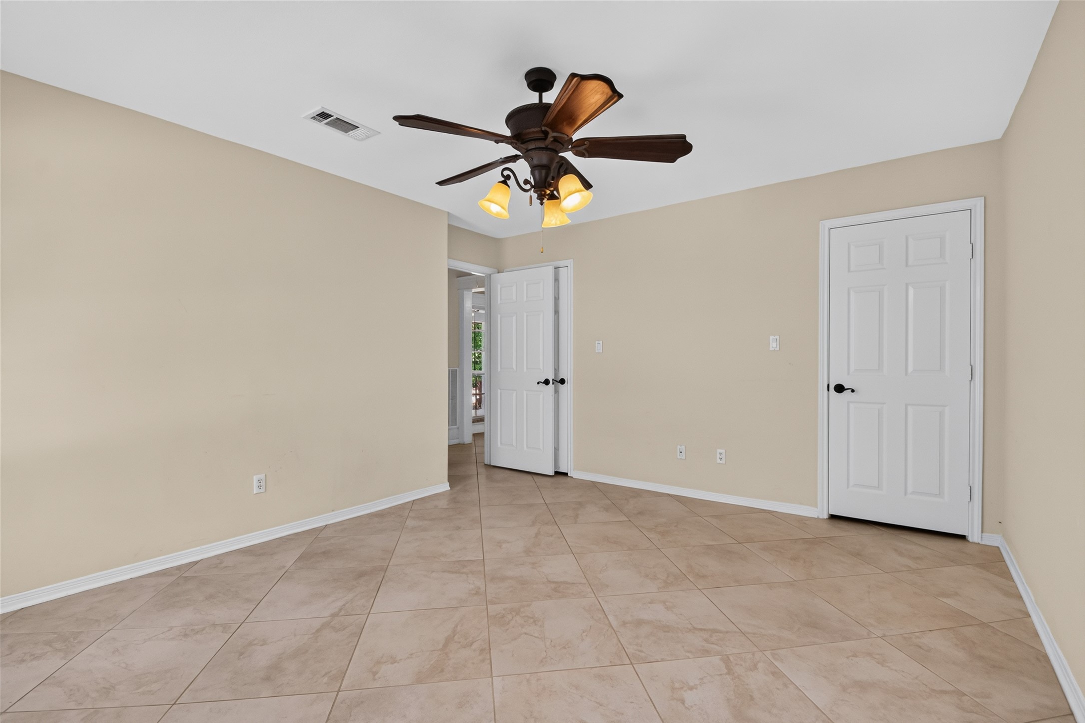 20203 Timber Ridge Drive Magnolia, TX 77355 - Photo 21 of 49 Bright and spacious secondary bedroom featuring durable tile flooring, neutral designer paint, and a ceiling fan with light fixture for year-round comfort.