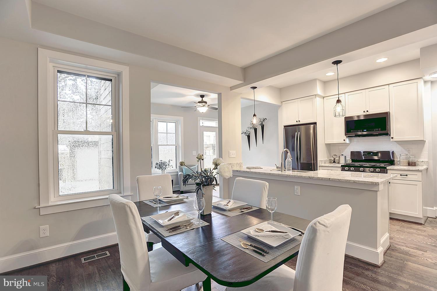 17 16th Street Southeast Washington, DC 20003 - Photo 8 of 29 a dining room with stainless steel appliances kitchen island granite countertop a dining table chairs and a refrigerator