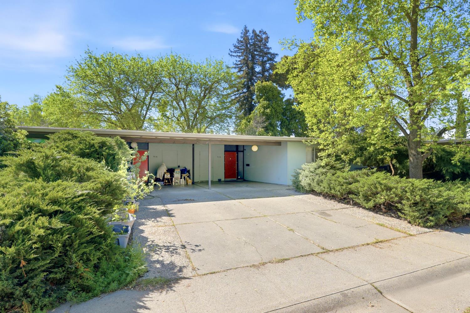 a front view of a house with a garden and a tree