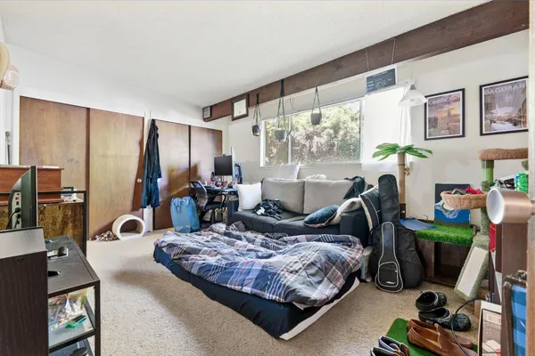 a bedroom with a bed a couch and a large window