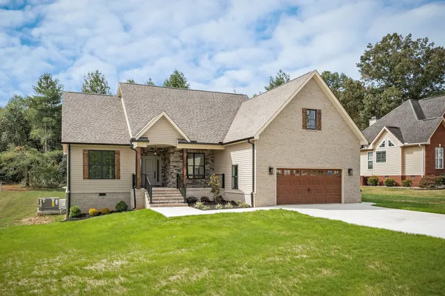 a view of a white house with a big yard and potted plants