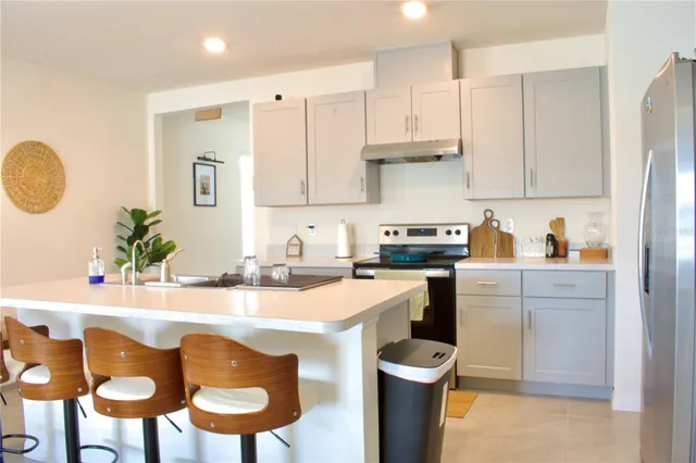 a kitchen with a sink a stove and chairs