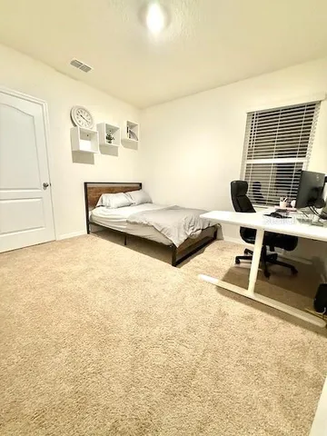 a bedroom with a bed and a desk