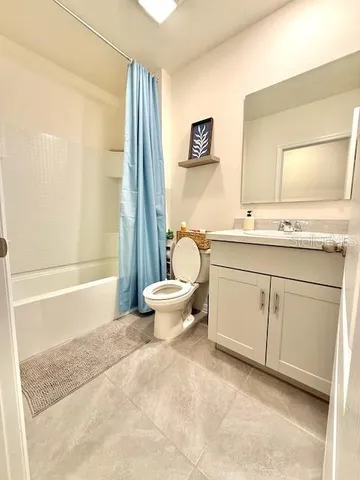 a spacious bathroom with a granite countertop sink toilet and a bathtub