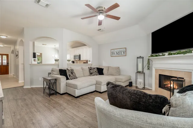 a living room with furniture a flat screen tv and a fireplace