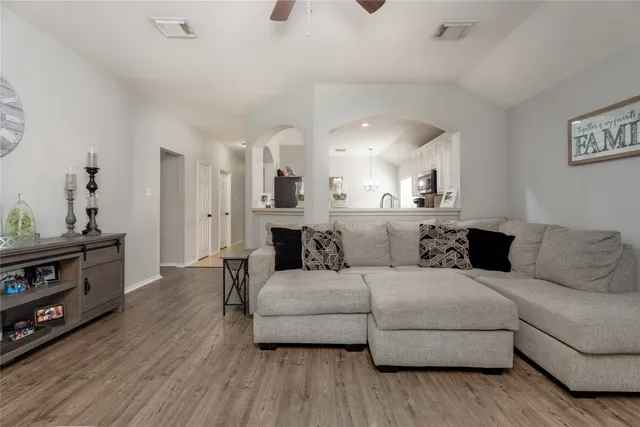 a living room with furniture and a wooden floor