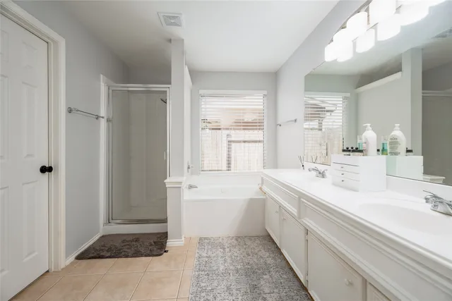 a spacious bathroom with a bathtub sink and mirror