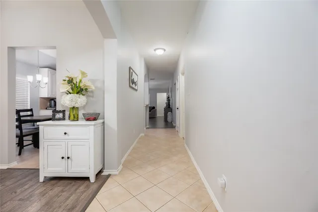 a view of a hallway with wooden floor and cabinet