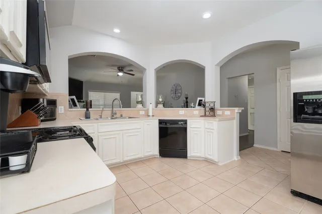 a kitchen with a sink a stove and chairs