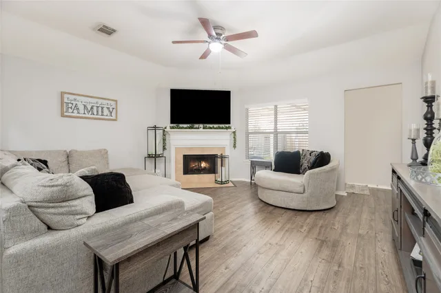 a living room with furniture a fireplace and a flat screen tv