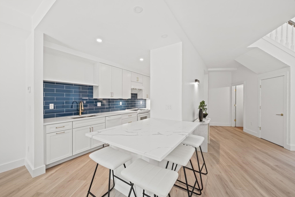 44 Ober Road, Unit 44 Newton, MA 02459 - Photo 8 of 41 a kitchen with stainless steel appliances kitchen island a table and chairs in it