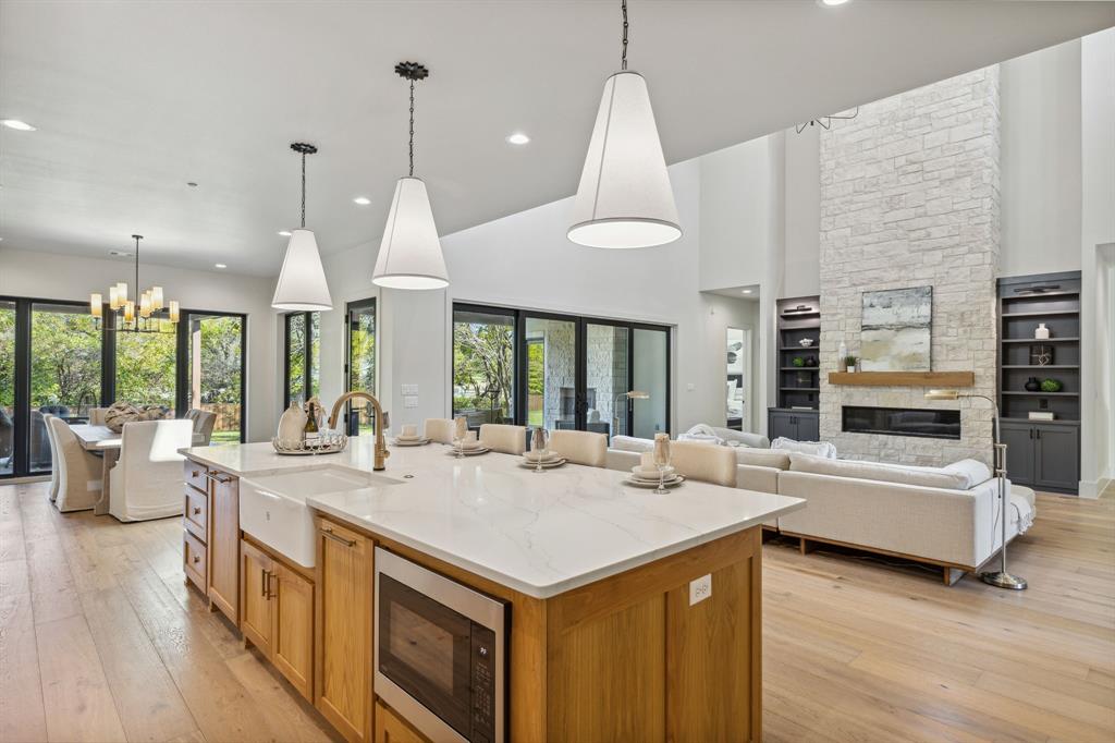 1405 Chelsea Rae Lane Keller, TX 76262 - Photo 12 of 35 a kitchen with a stove kitchen island and couches with wooden floor
