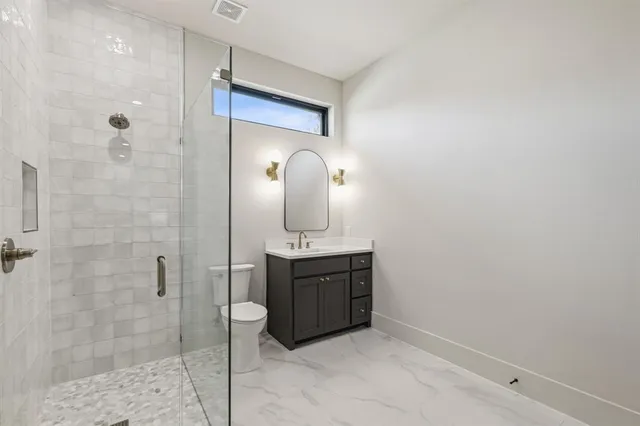 a bathroom with a sink a toilet and shower