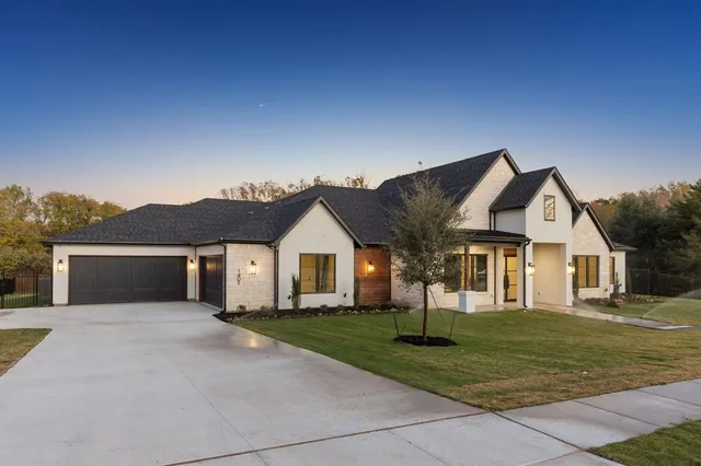 a front view of a house with a yard and trees