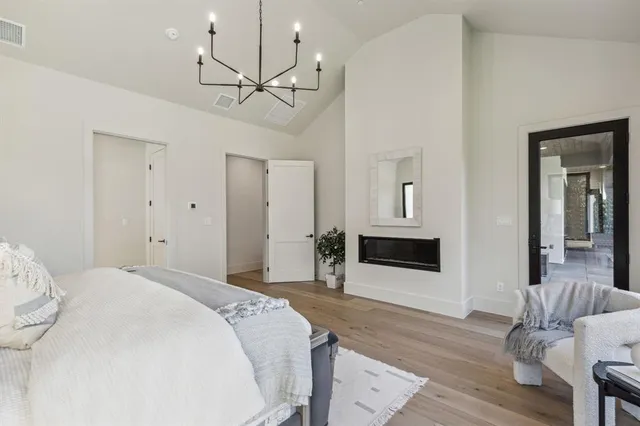 a spacious bedroom with a bed and a flat screen tv