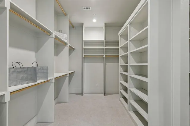a view of walk in closet with empty racks
