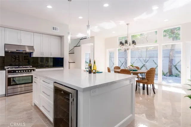 a kitchen with stainless steel appliances kitchen island granite countertop a stove and a sink