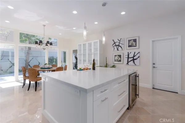 a large kitchen with kitchen island a sink a stove a dining table and chairs