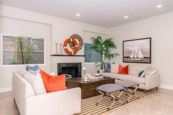 a living room with furniture a fireplace and a large window