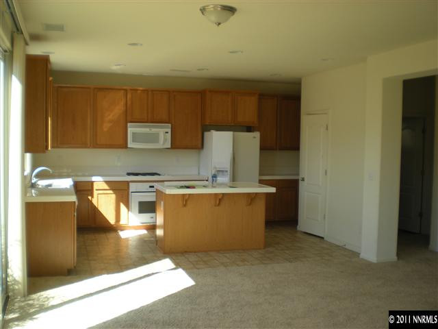 480 Stradella Court Reno, NV 89521 - Photo 4 of 13 a kitchen with stainless steel appliances granite countertop a refrigerator a stove and a sink with wooden cabinets