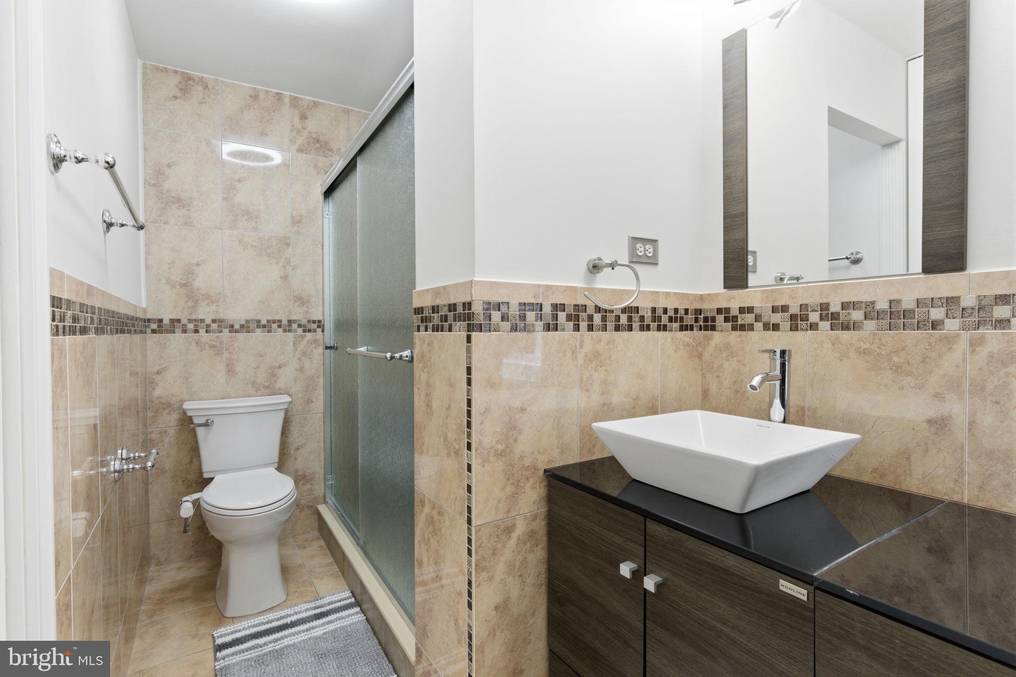 148 Rennard Street Philadelphia, PA 19116 - Photo 16 of 31 a bathroom with a sink a toilet a mirror and shower