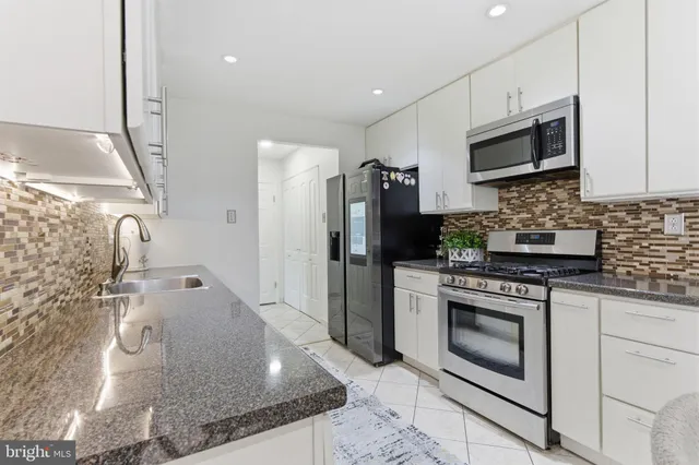 a kitchen with stainless steel appliances granite countertop a stove a microwave and a refrigerator