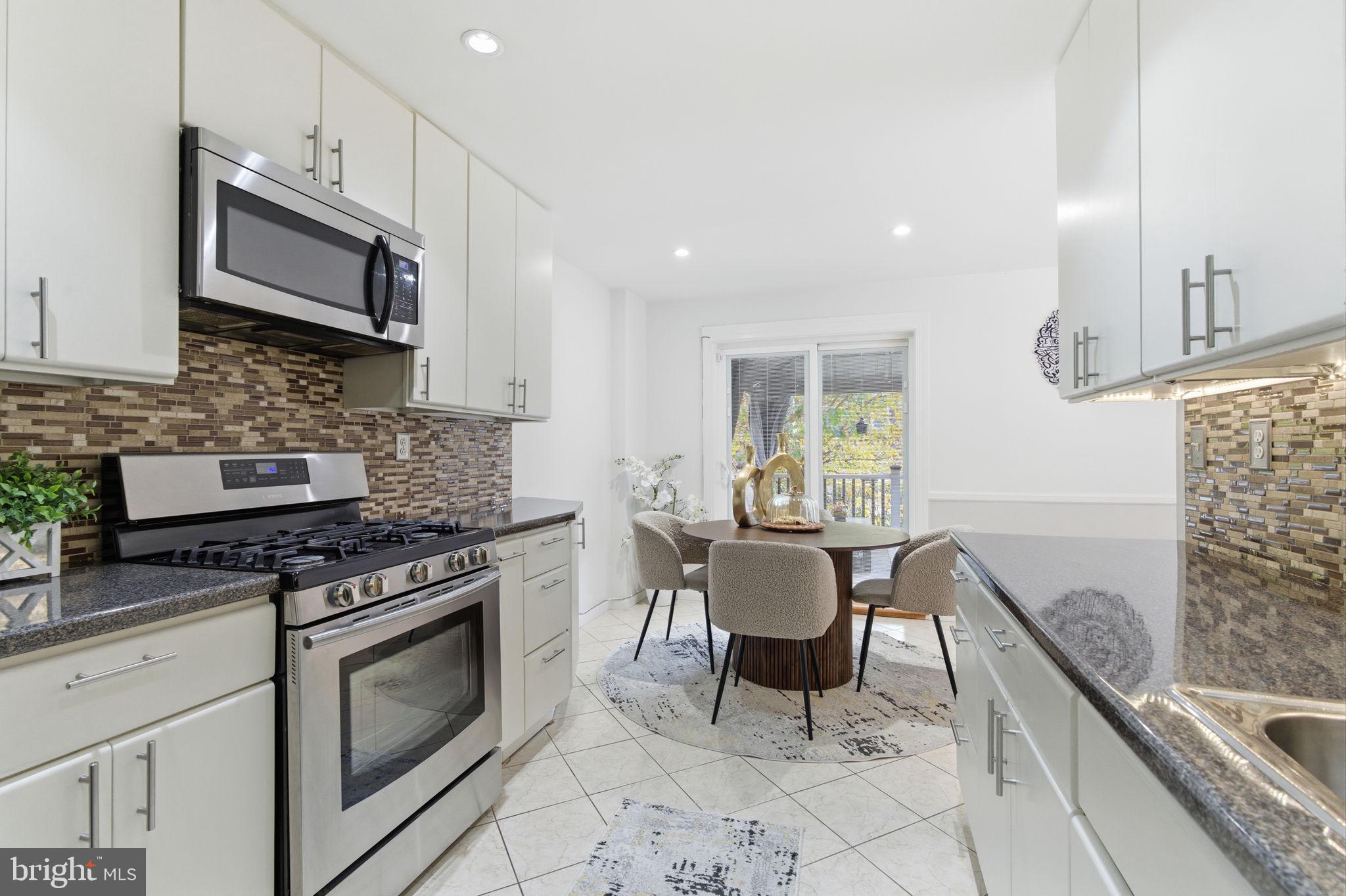148 Rennard Street Philadelphia, PA 19116 - Photo 10 of 31 a kitchen with stainless steel appliances granite countertop a stove a sink and a microwave